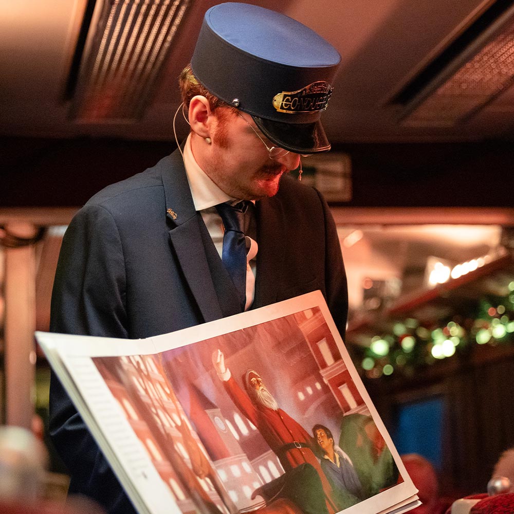 Conductor holding the book on board the polar express train ride